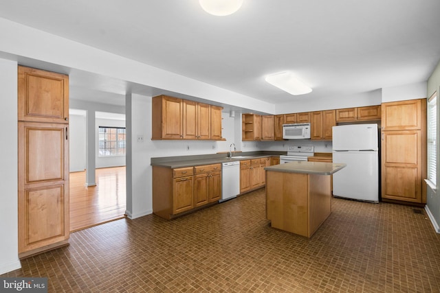 kitchen with sink, a center island, and white appliances