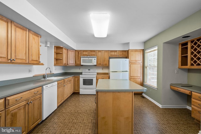 kitchen featuring built in desk, sink, a center island, and white appliances