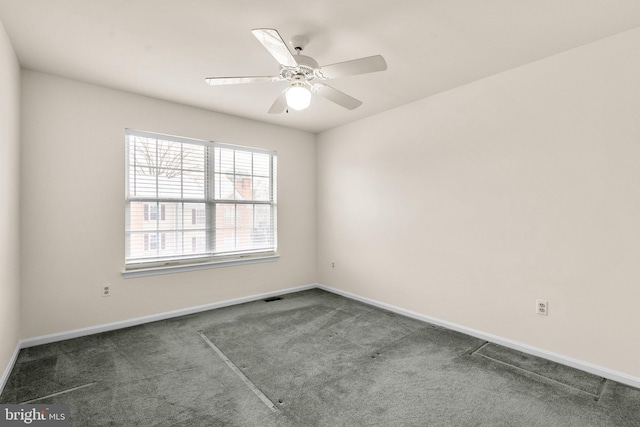 unfurnished room with ceiling fan and dark colored carpet