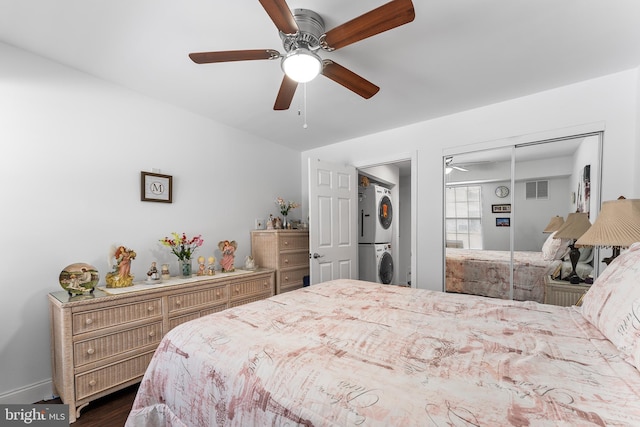 bedroom with stacked washer and dryer, ceiling fan, a closet, and dark hardwood / wood-style floors