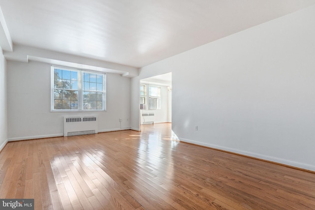 empty room featuring light hardwood / wood-style floors and radiator heating unit