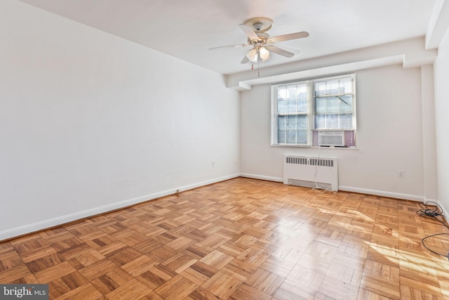 unfurnished room featuring radiator, cooling unit, ceiling fan, and light parquet floors