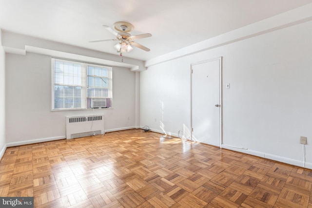 spare room with ceiling fan, cooling unit, radiator heating unit, and light parquet floors