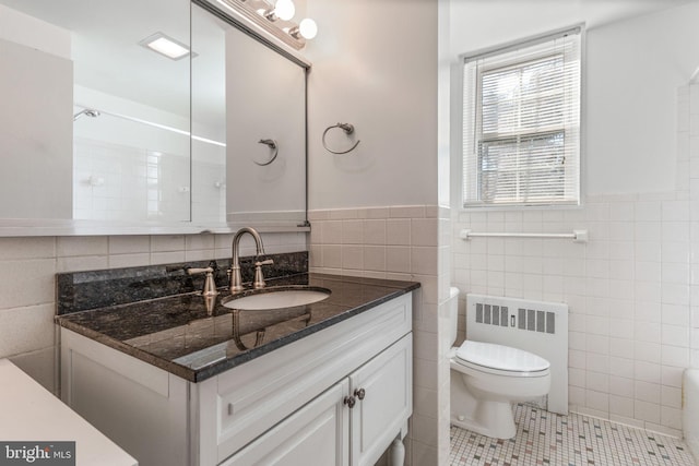 bathroom with tile walls, toilet, tile patterned floors, radiator heating unit, and vanity