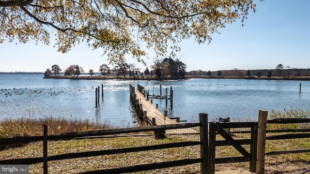 dock area featuring a water view and fence