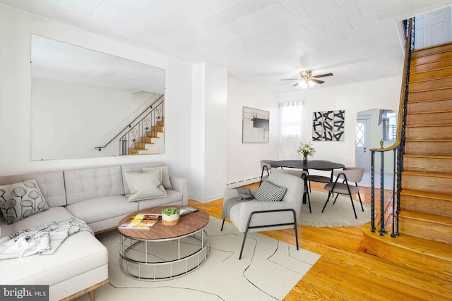 living room featuring hardwood / wood-style floors, ceiling fan, and baseboard heating