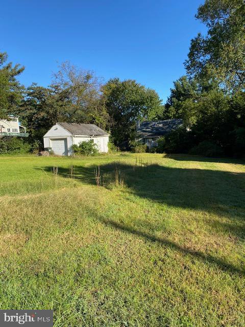 view of yard featuring a garage and an outbuilding