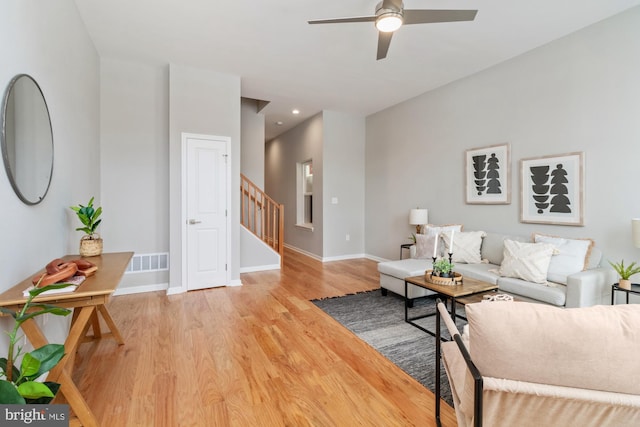 living room with light hardwood / wood-style floors and ceiling fan