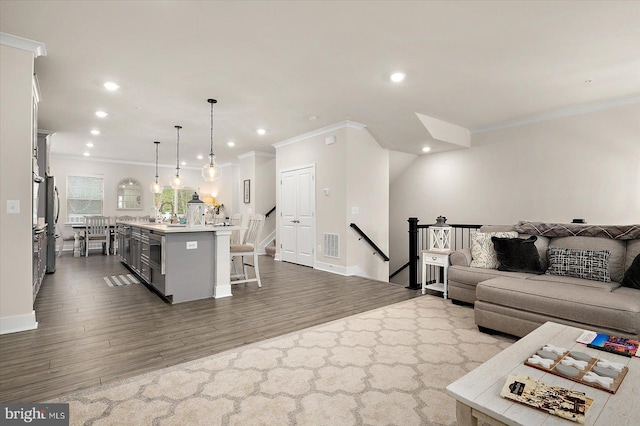 living room with hardwood / wood-style floors and crown molding