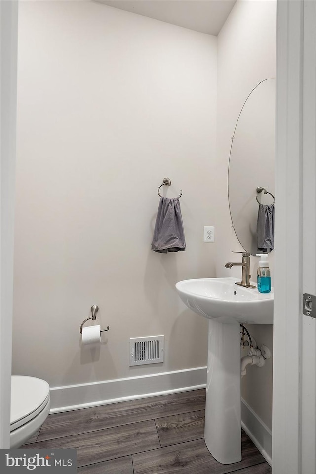 bathroom featuring sink, hardwood / wood-style floors, and toilet