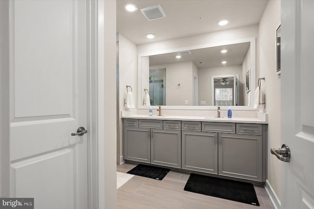 bathroom with a shower with door and vanity