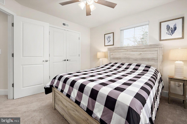 carpeted bedroom featuring ceiling fan and a closet