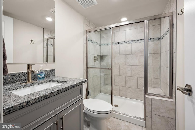 bathroom with vanity, toilet, and an enclosed shower