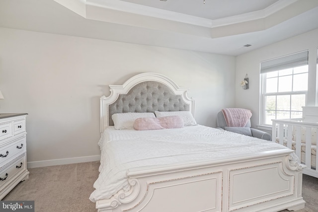 carpeted bedroom featuring a tray ceiling