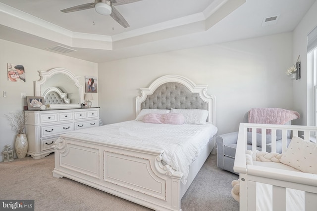 carpeted bedroom featuring a raised ceiling, ceiling fan, and crown molding