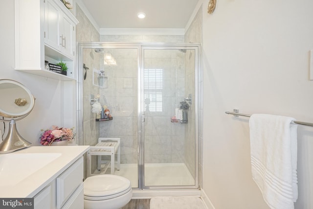 bathroom featuring vanity, toilet, and a shower with door