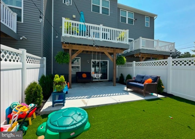 back of house featuring a yard, a patio area, and a wooden deck