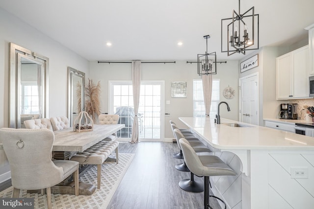 kitchen with pendant lighting, white cabinets, sink, decorative backsplash, and a large island