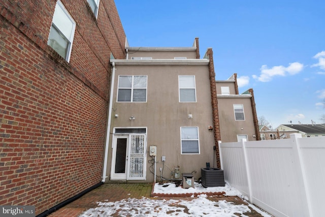 snow covered property featuring central AC