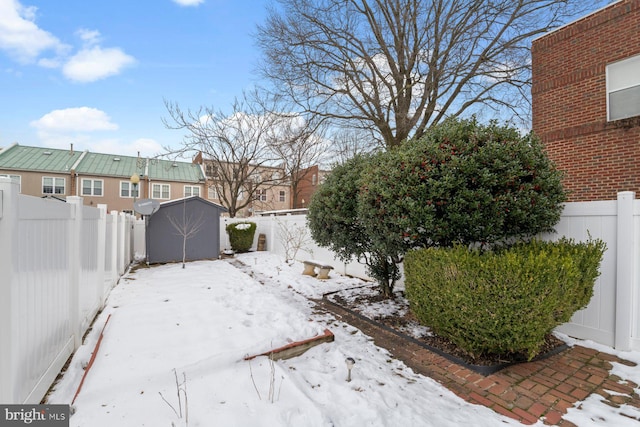 yard covered in snow featuring a shed