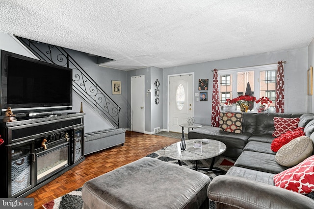 living room featuring a textured ceiling and dark parquet floors