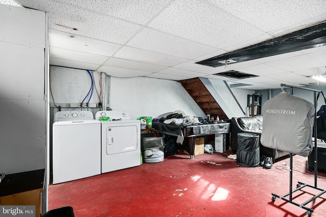 basement featuring washing machine and clothes dryer and a drop ceiling