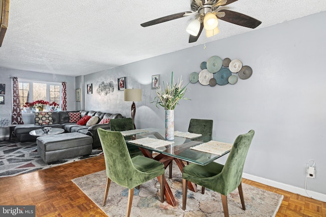 dining room featuring a textured ceiling, ceiling fan, and parquet flooring