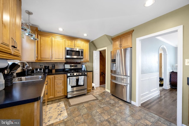 kitchen featuring decorative backsplash, sink, hanging light fixtures, and appliances with stainless steel finishes