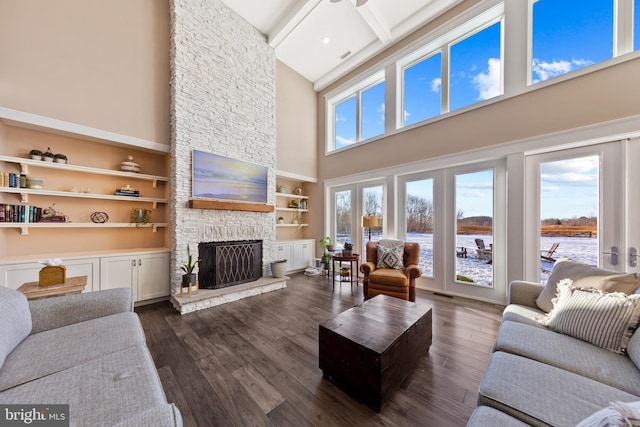 living room featuring beamed ceiling, french doors, dark hardwood / wood-style floors, and a fireplace