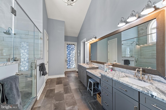 bathroom with vanity, walk in shower, and vaulted ceiling