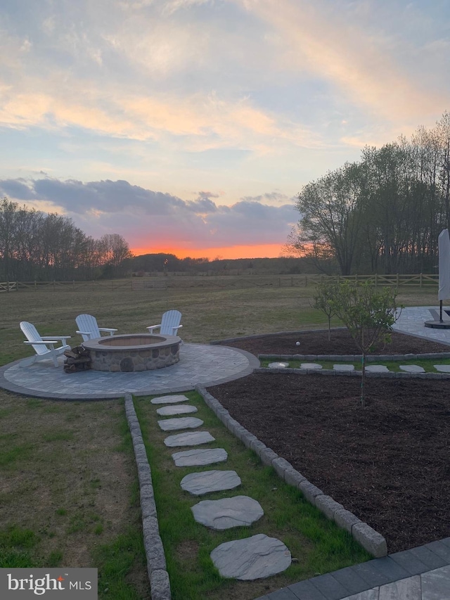 yard at dusk featuring a patio and an outdoor fire pit