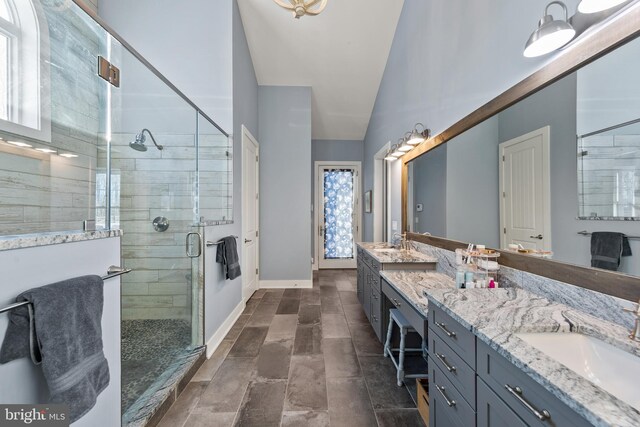 bathroom with a shower with shower door and vanity