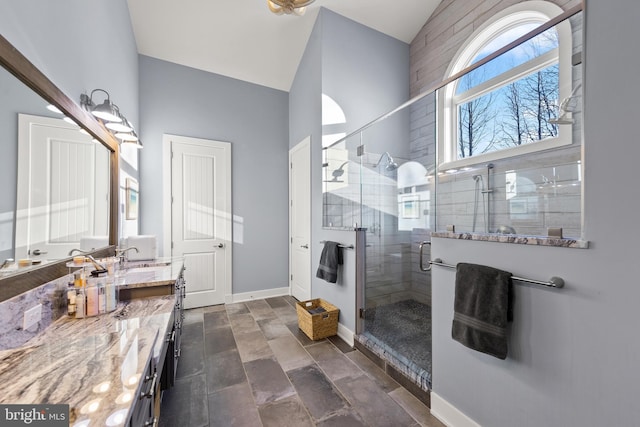 bathroom with walk in shower, vaulted ceiling, and vanity