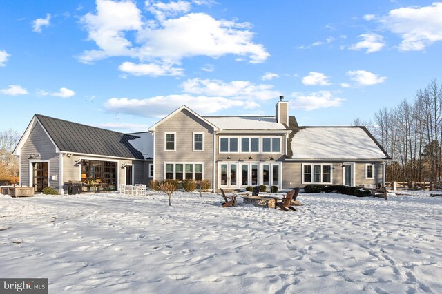 view of snow covered back of property