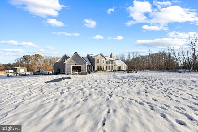 view of snow covered back of property