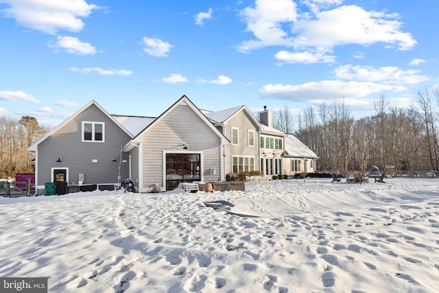 view of snow covered rear of property