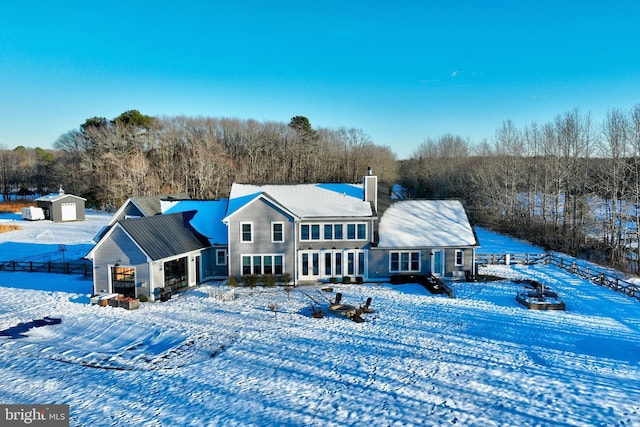 view of snow covered back of property