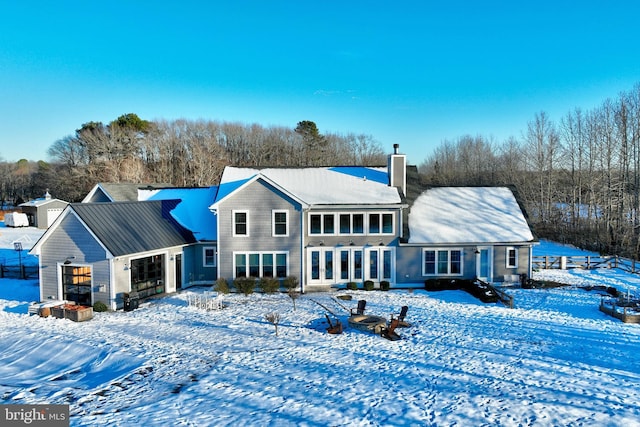 snow covered rear of property with a garage