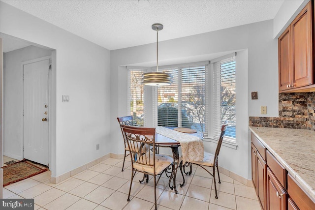 tiled dining space featuring a textured ceiling