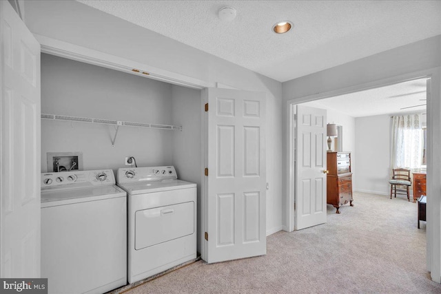 laundry room featuring light carpet, independent washer and dryer, and a textured ceiling