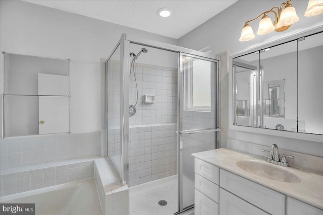 bathroom featuring vanity, a textured ceiling, and shower with separate bathtub