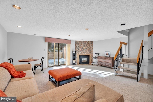 living room featuring a large fireplace, light colored carpet, and a textured ceiling