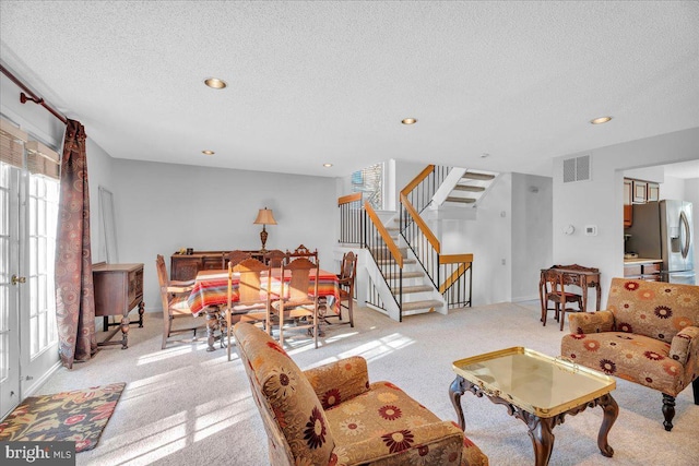 living room with a textured ceiling and light colored carpet