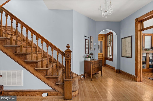 stairway with a chandelier and hardwood / wood-style floors