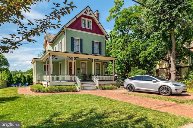 victorian home with covered porch and a front yard