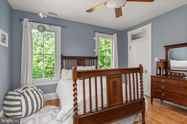 bedroom with multiple windows, ceiling fan, and light hardwood / wood-style flooring