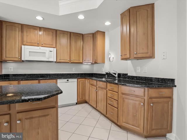kitchen with recessed lighting, a sink, light tile patterned flooring, white appliances, and dark stone counters