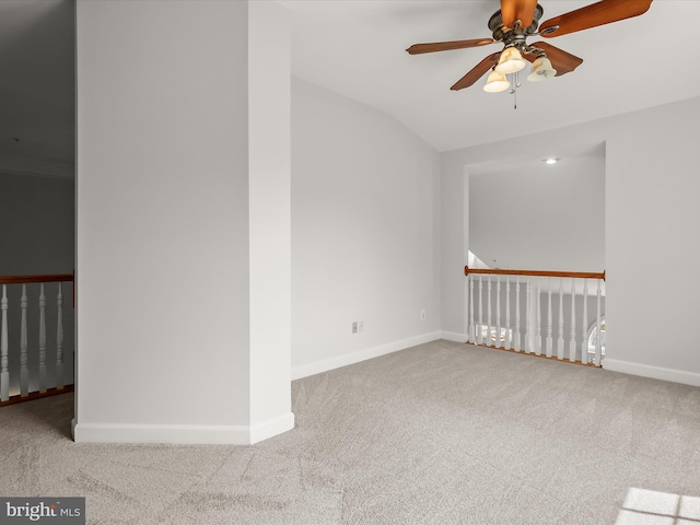 empty room with lofted ceiling, baseboards, carpet flooring, and ceiling fan