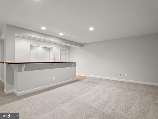 interior space with baseboards, recessed lighting, and light colored carpet