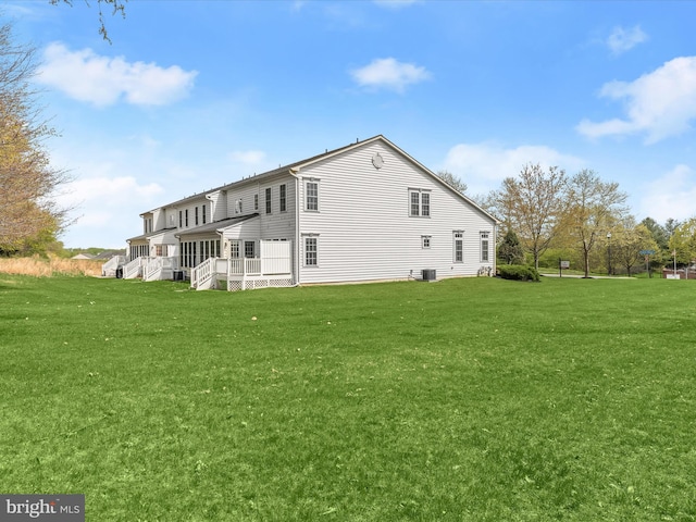 rear view of house featuring a yard and covered porch